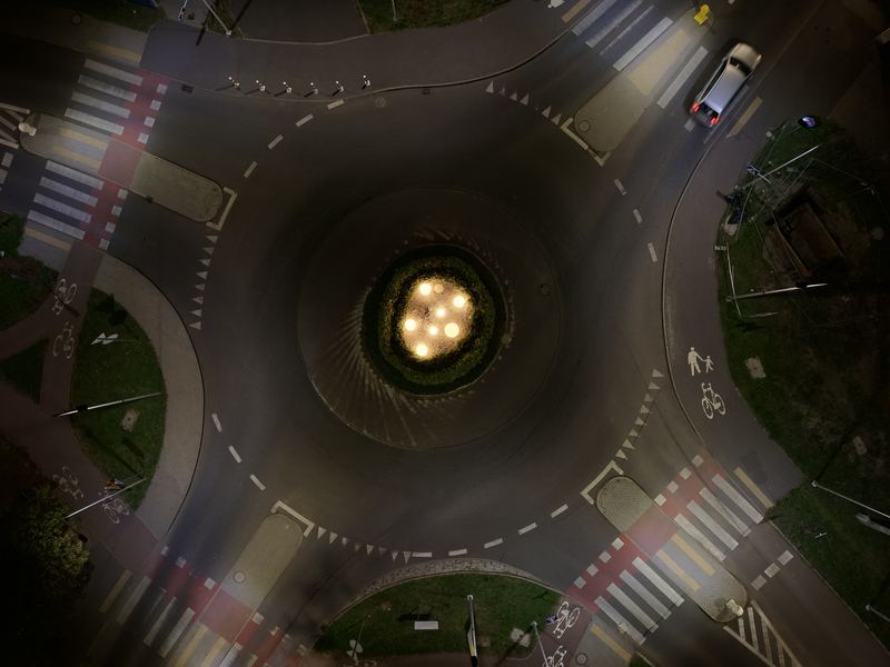 Skrzyżowanie z rondem widziane prostopadle z góry nocą